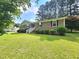 Inviting single-story brick home boasts lush green lawn, shrubbery and stairway to the front door at 112 Saddletree Rd, Oxford, NC 27565
