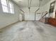 Spacious garage with a white refrigerator, garage door, and stairs with metal railings at 112 Saddletree Rd, Oxford, NC 27565