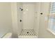 Tiled walk-in shower with flower mosaic floors and black fixtures offers a modern touch at 112 Saddletree Rd, Oxford, NC 27565