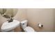 Bathroom featuring a white pedestal sink, toilet, and neutral wall color at 11612 Leesville Rd, Raleigh, NC 27613