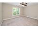 Well-lit bedroom features a large window, neutral walls, carpeted floors, and ceiling fan at 11612 Leesville Rd, Raleigh, NC 27613