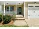 Close-up of the front door with decorative glass, stone steps, and manicured flower beds at 11612 Leesville Rd, Raleigh, NC 27613