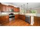 Spacious kitchen with stainless steel appliances, granite countertops, hardwood floors and hanging lights at 11612 Leesville Rd, Raleigh, NC 27613
