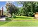 Lush green backyard with a large tree and a well-maintained lawn leading up to the house at 132 Lord Ashley Rd, Raleigh, NC 27610