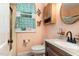 Cozy bathroom featuring a toilet, sink, vanity, medicine cabinet and colorful blue and green patterned curtains at 132 Lord Ashley Rd, Raleigh, NC 27610