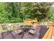 Outdoor deck features a table and chairs, perfect for dining and relaxation in a shaded, wooded setting at 132 Lord Ashley Rd, Raleigh, NC 27610