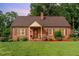 Charming brick home featuring a cozy front porch and beautifully manicured lawn at 132 Lord Ashley Rd, Raleigh, NC 27610