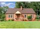 Charming brick home featuring a cozy front porch and beautifully manicured lawn at 132 Lord Ashley Rd, Raleigh, NC 27610