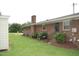 Brick home exterior featuring a green lawn, colorful hydrangea bushes, and a brick chimney at 1418 Sherron Rd, Durham, NC 27703