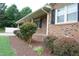 Charming brick home with a cozy front porch and manicured landscaping, including mulch beds at 1418 Sherron Rd, Durham, NC 27703