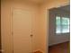 Hallway view showing hardwood floors, leading to a sunlit room with windows at 1418 Sherron Rd, Durham, NC 27703
