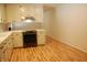 Bright kitchen with white cabinetry, stainless steel oven and light hardwood flooring at 1418 Sherron Rd, Durham, NC 27703