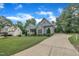 Long concrete driveway to home with well-maintained landscaping, gray siding and mature trees at 152 Abundant Ave, Angier, NC 27501