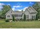 Charming two-story home featuring manicured landscaping, gray siding, black shutters, and a welcoming front porch at 152 Abundant Ave, Angier, NC 27501