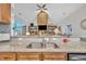 Kitchen sink area boasts granite countertops and a view of the living room's stone fireplace at 152 Abundant Ave, Angier, NC 27501