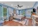 Spacious main bedroom featuring blue walls, plush carpet, ceiling fan, and two windows providing great light at 152 Abundant Ave, Angier, NC 27501