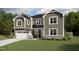 Two-story home with grey siding, a white garage door, and an inviting front porch and manicured lawn at 183 Yellow River Way, Garner, NC 27529