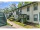 Two-story condo building with light-colored siding and green trim with wood stairs at 205 Ashley Forest Rd # Bldg D, Chapel Hill, NC 27514
