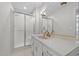 Bathroom showcasing a glass-enclosed shower and a vanity with white countertops and gold fixtures at 211 Forestview Dr, Elon, NC 27244