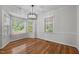 Dining room featuring hardwood floors, modern lighting fixture, and large windows for natural light at 211 Forestview Dr, Elon, NC 27244