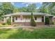 Charming ranch home featuring a covered front porch, brick accents, and a well-maintained lawn at 211 Forestview Dr, Elon, NC 27244