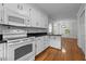 Modern kitchen with white cabinetry, tile backsplash, granite countertops, and hardwood floors at 211 Forestview Dr, Elon, NC 27244