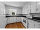 Well-lit kitchen featuring white cabinets, modern appliances, and hardwood floors at 211 Forestview Dr, Elon, NC 27244