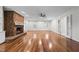 Open living room featuring hardwood floors, brick fireplace, and white wainscoting at 211 Forestview Dr, Elon, NC 27244