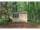 Small storage shed with window is nestled among the trees at 211 Forestview Dr, Elon, NC 27244