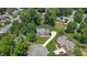 Aerial view of a brick two-story home with a long driveway and lush green lawn and fenced backyard at 213 Brompton Ct, Burlington, NC 27215
