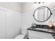 Elegant half bathroom with white wainscoting, modern fixtures, and a round mirror at 213 Brompton Ct, Burlington, NC 27215