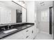 Modern bathroom featuring dual sinks, black countertops, and a glass-enclosed shower at 213 Brompton Ct, Burlington, NC 27215
