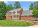 Beautiful red brick home with manicured lawn, charming front porch and well-maintained landscaping at 213 Brompton Ct, Burlington, NC 27215
