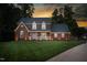 Inviting two-story brick home with a manicured lawn and sidewalk leading to the driveway at 213 Brompton Ct, Burlington, NC 27215