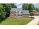 Stunning brick home featuring a meticulously manicured lawn and mature trees in a desirable neighborhood at 213 Brompton Ct, Burlington, NC 27215