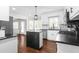 Bright kitchen boasts a kitchen island with breakfast bar, stainless steel appliances, and wood floors at 213 Brompton Ct, Burlington, NC 27215