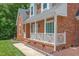 Cozy front porch with decorative trim details on a classic brick home at 213 Brompton Ct, Burlington, NC 27215