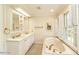 Bathroom with double sinks, garden tub, and natural light from shuttered windows at 322 Gravley Dr, Rocky Mount, NC 27804