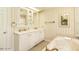 Elegant bathroom featuring double vanity with a soaking tub and striped wallpaper at 322 Gravley Dr, Rocky Mount, NC 27804