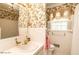 Bathroom with vintage design, floral wallpaper, and white tile at 322 Gravley Dr, Rocky Mount, NC 27804