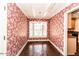 Bright breakfast nook with bay window, red floral wallpaper, and brick flooring at 322 Gravley Dr, Rocky Mount, NC 27804