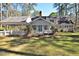 Charming home exterior with a well-manicured lawn, inviting porch, and mature trees, all under a sunny sky at 322 Gravley Dr, Rocky Mount, NC 27804
