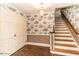Elegant foyer with decorative wallpaper, traditional staircase, and brick flooring adding unique character at 322 Gravley Dr, Rocky Mount, NC 27804