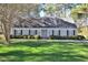 Charming home featuring a lush green lawn, mature trees, and manicured landscaping, framed by traditional shutters at 322 Gravley Dr, Rocky Mount, NC 27804