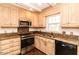 Cozy kitchen with wooden cabinets, granite countertops, and stainless steel appliances at 322 Gravley Dr, Rocky Mount, NC 27804
