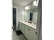 Bathroom featuring double sinks, white cabinets, and a large mirror with vanity lighting at 325 Olde Liberty Dr, Youngsville, NC 27596
