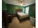Green bedroom showcases a bed with a wooden headboard, desk, and shuttered windows at 325 Olde Liberty Dr, Youngsville, NC 27596