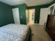 The bedroom features green walls, white trim, and a door leading to another room at 325 Olde Liberty Dr, Youngsville, NC 27596