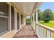 Covered porch with wood flooring and white railing, perfect for outdoor relaxation at 34 Scotts Creek Run, Angier, NC 27501
