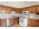 Traditional kitchen featuring wood cabinets, white appliances, and ample countertop space at 34 Scotts Creek Run, Angier, NC 27501
